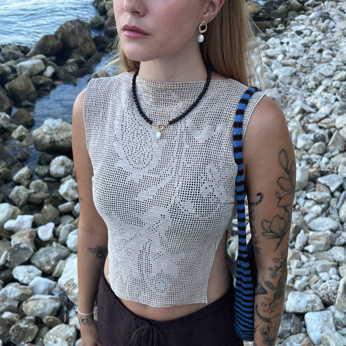 Garnet Pearl Drop Necklace - model lifestyle view wearing necklace paired with Ripple Pearl Drop Stud Earrings on beach | Token & Pearl